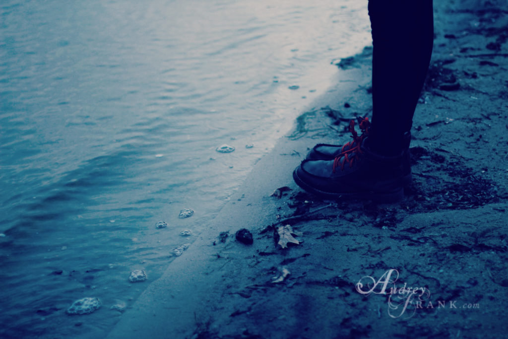 person standing in the sand on the shore.