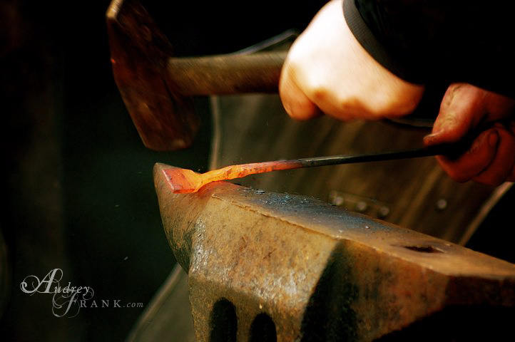 hand hammering hot iron on the forge
