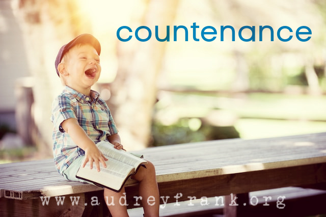 a little boy laughing in sunlight as he holds a bible with the word Countenance describing the subject of the post