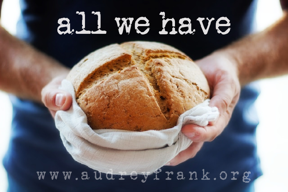 a person holding out a fresh loaf of bread with the words, "All We Have" describing the subject of the post.