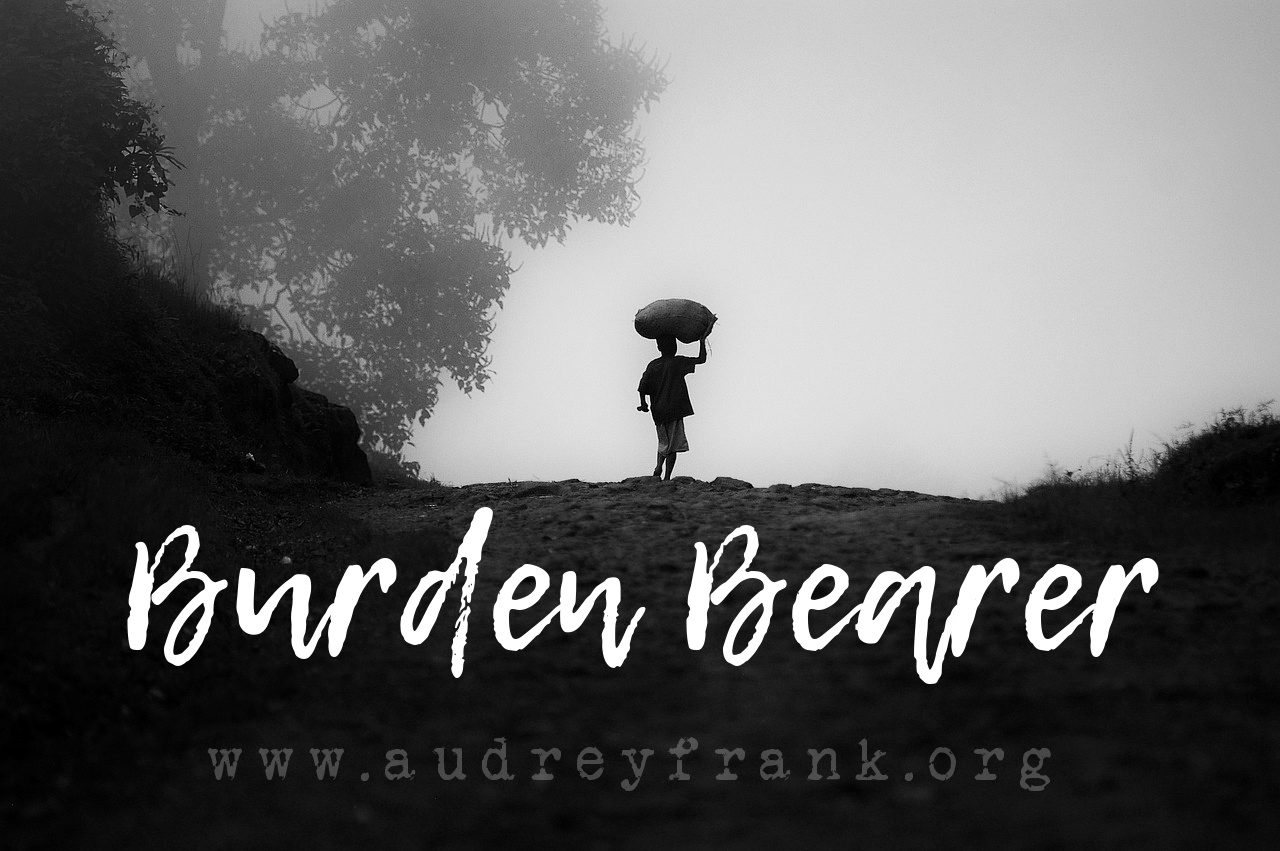  Silhouette of a person carrying a heavy load on their head with the words Burden Bearer describing the subject of the post.
