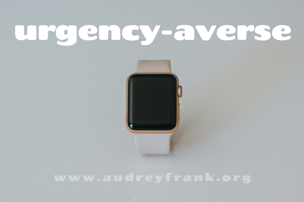 a watch with black screen and the words "urgency-averse" describing the subject of the post.