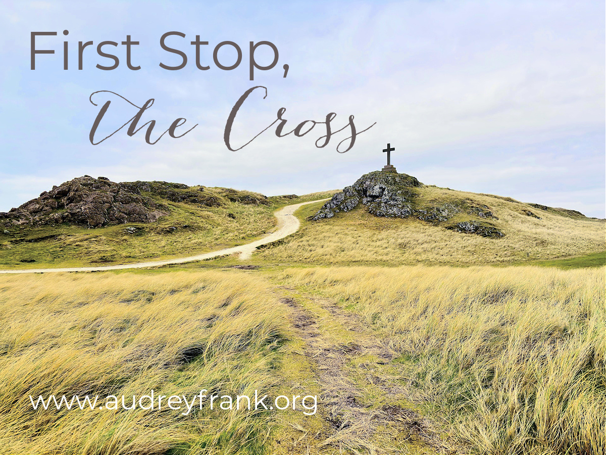 A path leading to a cross on a grassy hill with the words First Stop, the Cross describing the subject of the post.