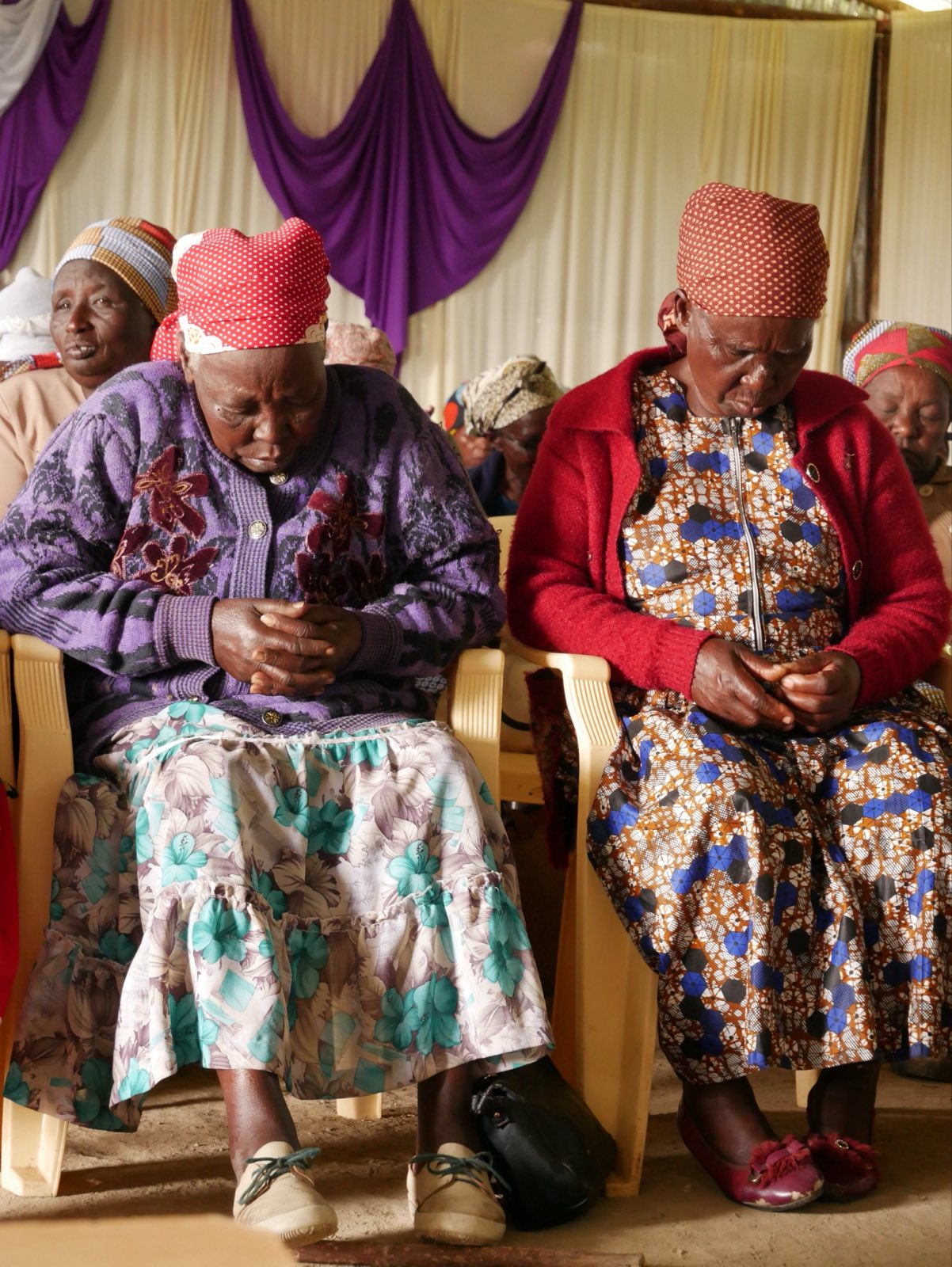 women with heads bowed in prayer