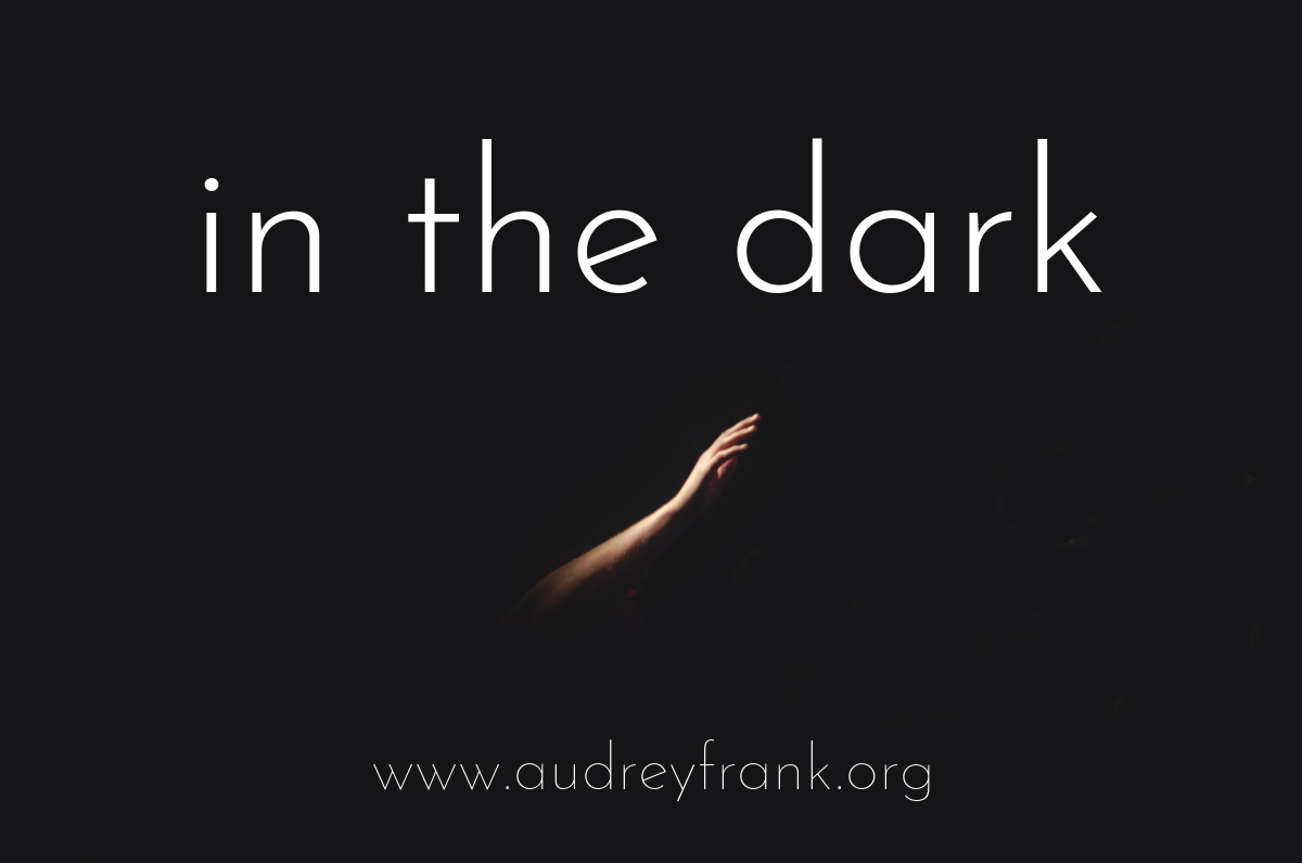 a hand reaching upwards in the dark, with the words "In the Dark" stating the title of the post.